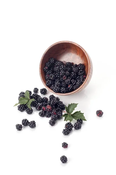 Чернослив в деревянном банте. Спелые и вкусные черные ягоды изолированы на белом. Blackberries на белом фоне . — стоковое фото