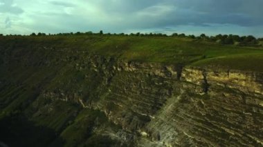 Havadan görünüm. Kamera arka planda kayalık kayalıklar ve karlı zirveleri ile güzel bir derin kanyon üzerinde uçar. İnanılmaz dağ manzarası.
