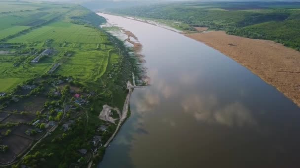 Vliegen over de rivier en een klein dorpje op een zonnige zomerdag. Dniester rivier in Moldavië. — Stockvideo