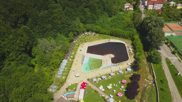 Vedere de la o dronă deasupra piscinei înconjurată de copaci verzi. Bai Herculane, Romania . — Videoclip de stoc