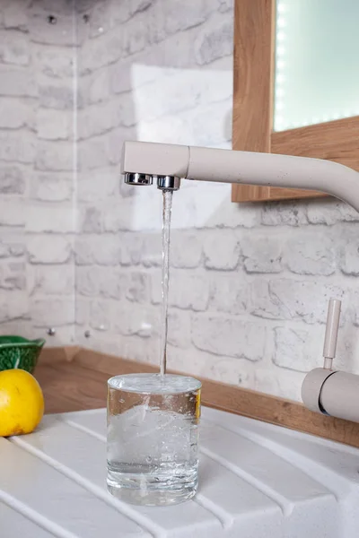 Cam mutfakta musluk suyu ile doldurulur — Stok fotoğraf