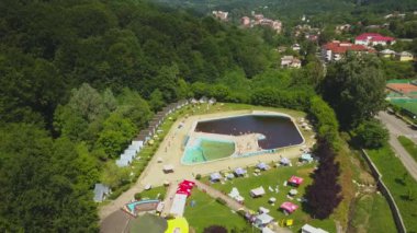 Yeşil ağaçlarla çevrili havuz üzerindeki bir drone 'dan Topview. Herculane baths, Romanya.