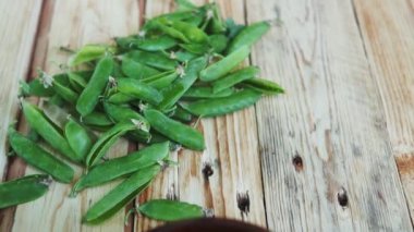 kahverengi çanak içinde closeup yeşil bezelye, ahşap masa üzerinde.