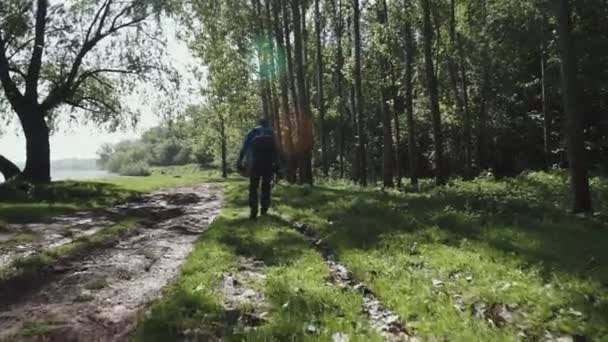 homme randonnée à travers les bois à la recherche de photos. Côté suivant.Personnes réelles Voyageur millénaire randonneur adulte photographe masculin marchant sur le terrain rural pour prendre des photos en saison .
