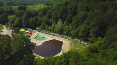 Yeşil ağaçlarla çevrili havuz üzerindeki bir drone 'dan Topview. Herculane baths, Romanya.
