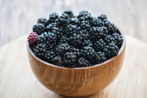 Sweet blackberry in wooden bowl on wooden table — Stock Photo, Image