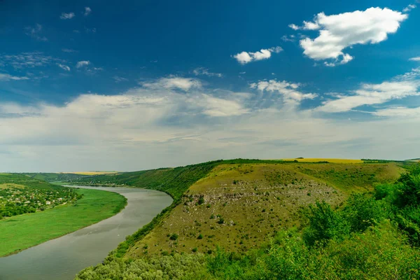 Річка в зеленому пейзажі і хмарах з блакитним небом — стокове фото