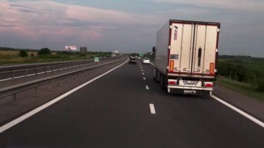 Fpv: Otoban boyunca sürüş. Arabanın camından yolun görünümü. Arabalar toplantıya gider.