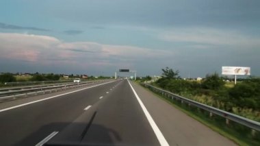 Fpv: Otoban boyunca sürüş. Arabanın camından yolun görünümü. Arabalar toplantıya gider.