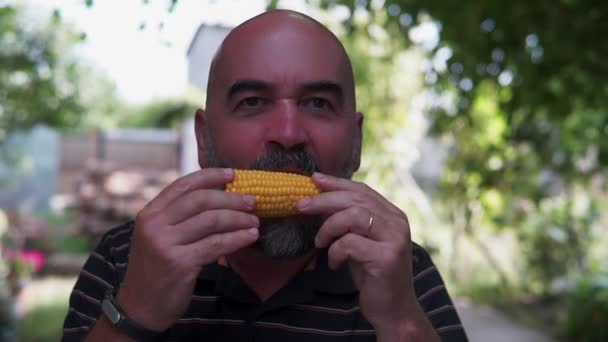 Homem Com Uma Barba Cinza Come Milho Cozido — Vídeo de Stock