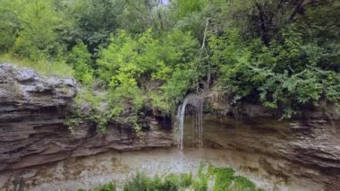 Yeşil ormanda smalll şelale üzerinde uçuş. Drone 4k 30fps ile çekildi