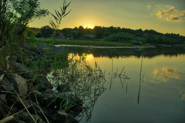 Kleurrijke zonsondergang aan de oever van de rivier in de zomer — Stockfoto