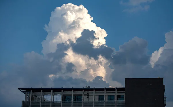 Modern building against the sky with thunderclouds — Stock Photo, Image