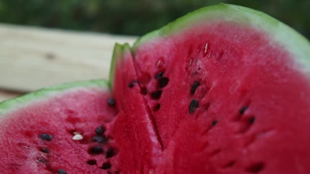 Verse gesneden watermeloen houten achtergrond in de tuin — Stockvideo