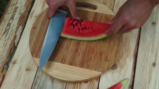 Hombre corte sandía en una mesa de madera . — Vídeos de Stock