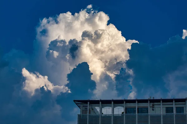 Modern building against the sky with thunderclouds — Stock Photo, Image