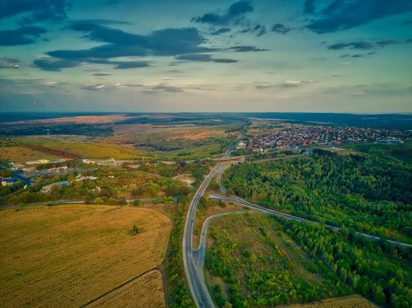 Vista aérea de la carretera con bosque y campos al atardecer. Paisaje otoñal . — Foto de Stock