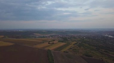 Dramatik sonbahar günbatımı manzara üzerinde Aerial View Drone Uçuş. Küçük bir köy çayırları, turuncu tepeleri kuşattı. 4k