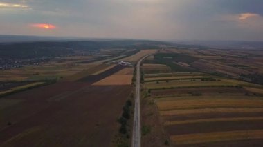 Gün batımında orman ve tarlalar ile karayolu havadan görünümü. Sonbahar manzarası.