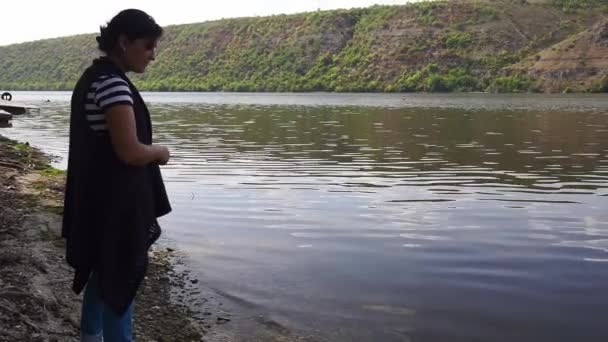 Красивая Молодая Женщина Идет Вдоль Берега Реки Собирает Раковины — стоковое видео