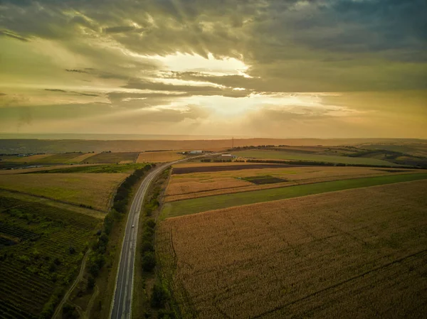 Vista aérea de la carretera con bosque y campos al atardecer. Paisaje otoñal . —  Fotos de Stock