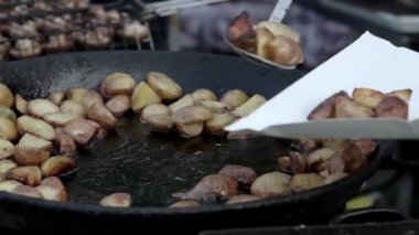 Aşçı kızarmış patatesi tabağa koyar. Sokak yemeği..