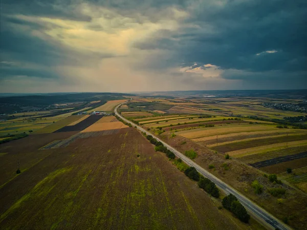 Vista aérea de la carretera con bosque y campos al atardecer. Paisaje otoñal . — Foto de Stock