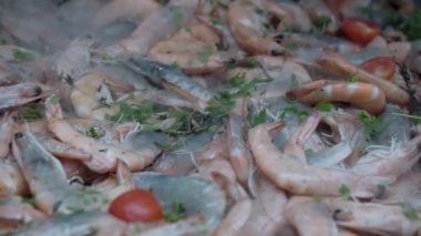 Aşçı büyük bir tavada kabuklu karides pişiriyor.