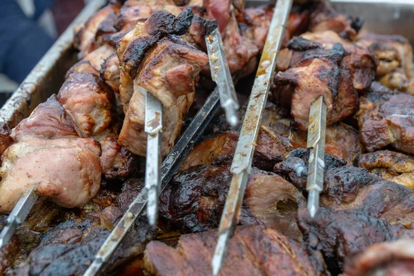 Marinated meat grilling on smoking grill. Close up fresh meat skewers on grill at bbq event. Cooking bbq meat at summer picnic — Stock Photo, Image