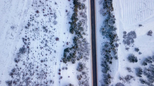 Camino de campo que pasa por los hermosos paisajes cubiertos de nieve. Vista aérea. Fotografía de drones —  Fotos de Stock