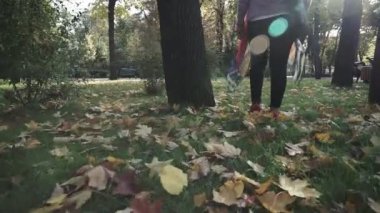 Sonbahar parkında yürüyen beyaz kadın.