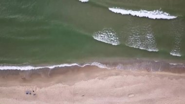 Plaj ve deniz havası manzarası. Denizde yumuşak dalgalar ve çakıl taşları. Suyun rengi sabahları çok güzel parlıyor. 4k video