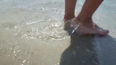 Günbatımında Ocean Beach 'te yürüyen bir kadının güzel sahnesinde. Plajda Yürüyen Kadın Bacakları 'nın Yakın Çekimi