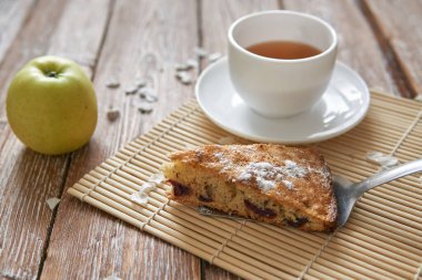 Tarçınlı ev yapımı elmalı turta ve ahşap masada çay..
