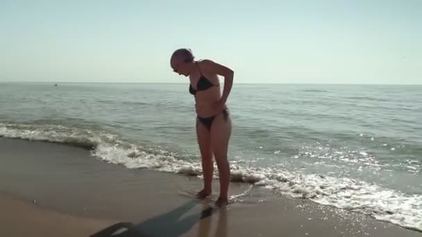 Μεσήλικη Γυναίκα Μαγιό Στέκεται Στην Παραλία Δίπλα Στη Θάλασσα — Αρχείο Βίντεο