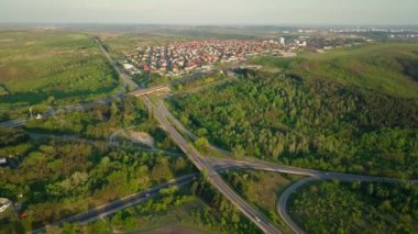 Akşam trafiği üzerinde uçan bir insansız hava aracı. Otoyol ve kamyonlar, kavşak, iki katlı yol ayrımı. Çevre yolu, hat.