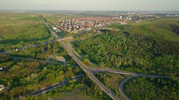 Vol aérien à drone élevé au-dessus de la circulation routière du soir. Autoroute et passage supérieur avec voitures et camions, échangeur, carrefour routier à deux niveaux. Autoroute, ligne.