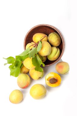 Tahta kasede taze kayısılar, beyaz arka planda izole edilmiş..