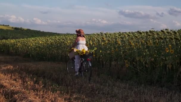 Женщина Шляпе Белом Платье Велосипедом Едет Поле Подсолнухами — стоковое видео