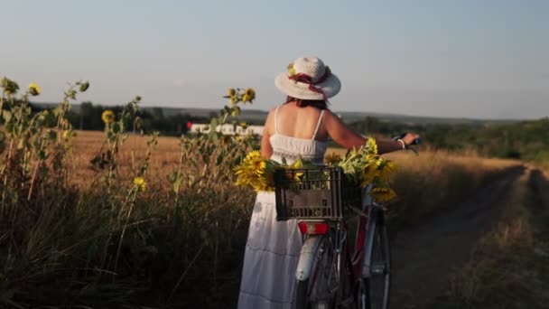 Strzał Młodej Kobiety Lekkiej Sukience Kapeluszu Jeżdżącej Rowerze Wiejskich Drogach — Wideo stockowe