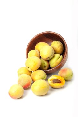 Tahta kasede taze kayısılar, beyaz arka planda izole edilmiş..