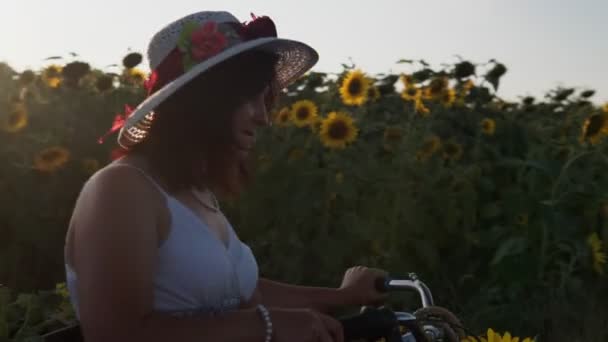 Şapkalı Bisikletli Beyaz Elbiseli Bir Kadın Ayçiçekleri Ile Polenlerin Arasında — Stok video