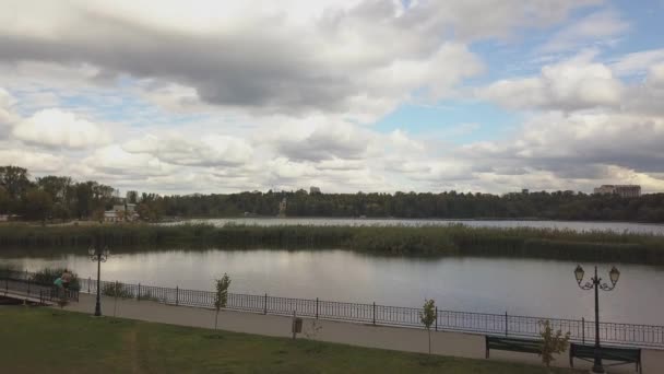 秋の木々のある公園内の湖の空中ビュー キシネフ モルドバ 水の上の壮大な航空便 昼間は色とりどりの紅葉 ドローンは黄色の木で湖に沿って飛ぶ ドローンショット — ストック動画