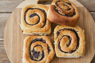 Kahverengi ahşap masa üzerinde kuru üzümlü lezzetli çörekler. Taze fırın. Kahvaltı. Ekmek. en üstteki görünüm