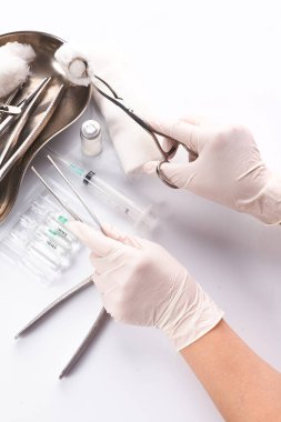 Kapalı el dişçisi hasta dişlerini tedavi etmek için bir araç seçiyor.