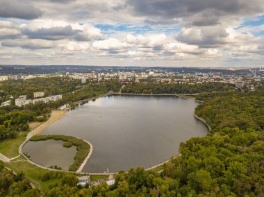 Sonbahar ağaçlarıyla dolu bir parktaki göl manzarası. Kishinev, Moldova. Suyun üzerinde destansı bir uçuş. Gündüzleri renkli sonbahar ağaçları.