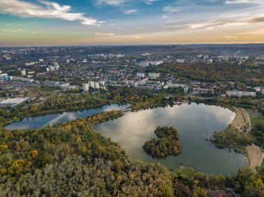 Sonbahar ağaçlarıyla dolu bir parktaki göl manzarası. Kishinev, Moldova. Suyun üzerinde destansı bir uçuş. Gündüzleri renkli sonbahar ağaçları.