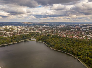 Sonbahar ağaçlarıyla dolu bir parktaki göl manzarası. Kishinev, Moldova. Suyun üzerinde destansı bir uçuş. Gündüzleri renkli sonbahar ağaçları.