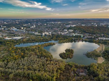 Sonbahar ağaçlarıyla dolu bir parktaki göl manzarası. Kishinev, Moldova. Suyun üzerinde destansı bir uçuş. Gündüzleri renkli sonbahar ağaçları.