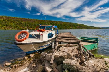 Yansıması olan bir nehre demirlenmiş küçük bir balıkçı teknesi.